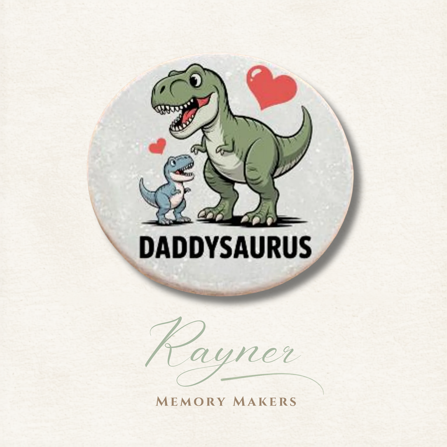 Circular product with cartoon dinosaurs and 'Daddysaurus' text on a light background, featuring the brand 'Rayner Memory Makers'.