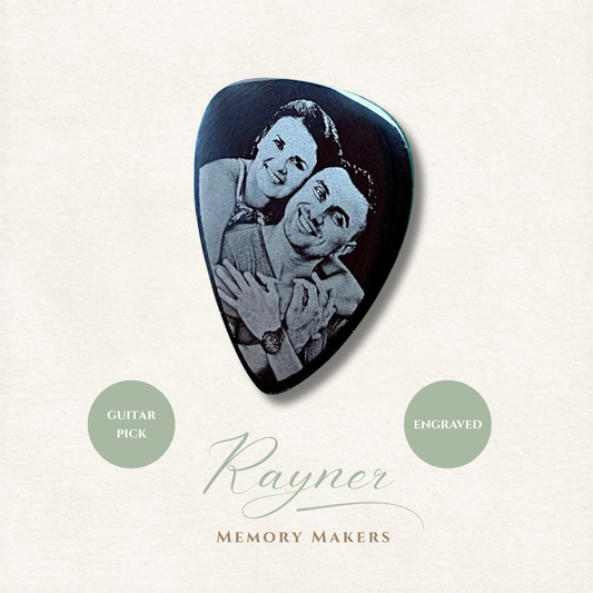 Guitar pick with engraved image of two people hugging, branded 'Rayner Memory Makers'.