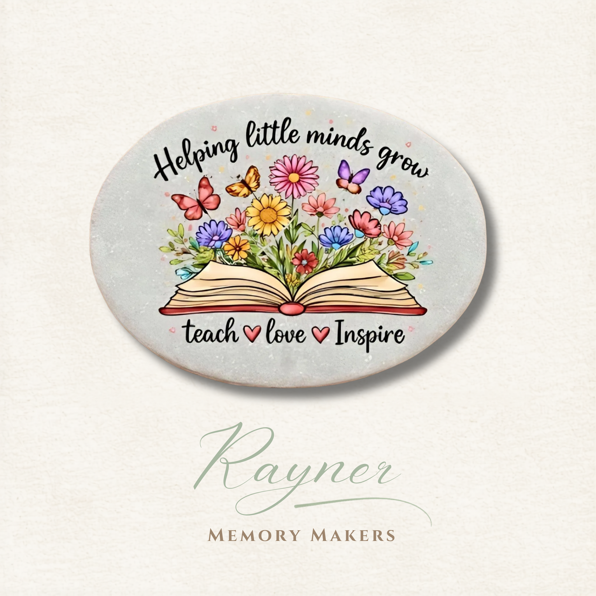 Round ceramic coaster with colorful flowers, book, and text 'Helping little minds grow, teach love inspire' on a light background.